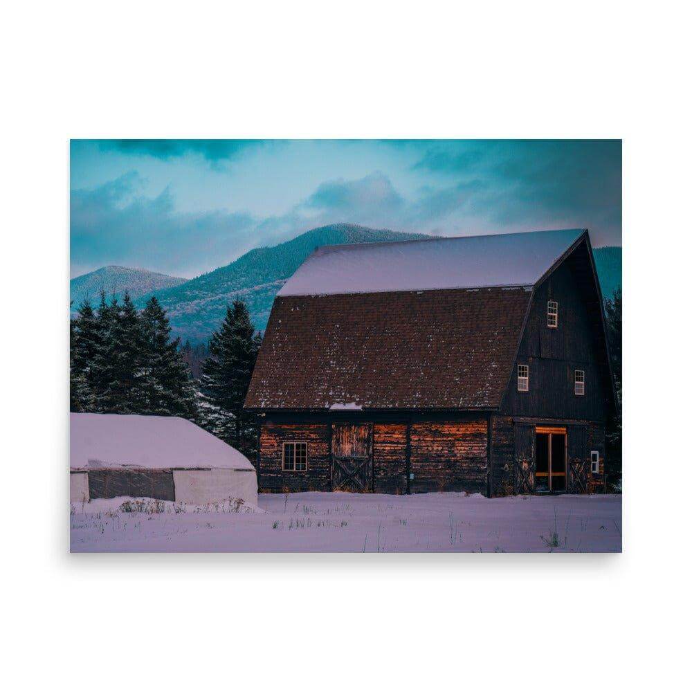 Rustic barn in snowy Adirondack Mountains with a partly cloudy sky at twilight.