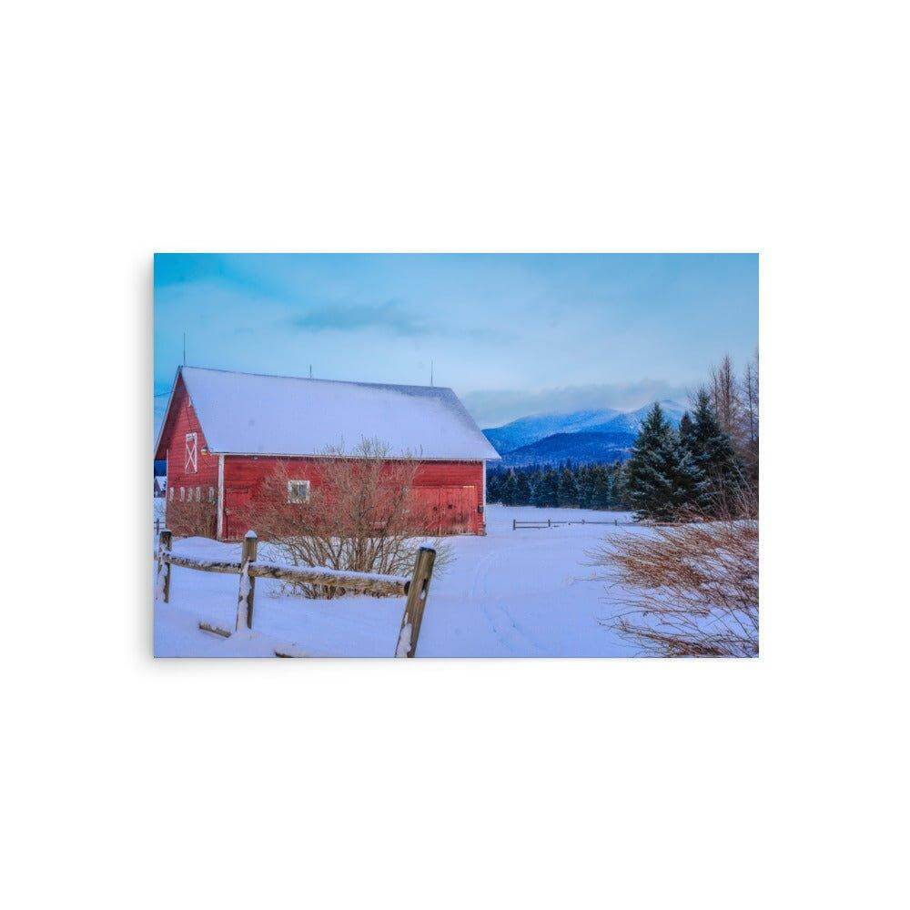 Red mountain barn in snowy winter landscape with blue sky and trees, high-quality matte-finish poster for home decor.